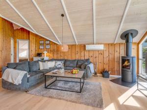a living room with a couch and a fireplace at Holiday Home Bole - 10km from the sea by Interhome in Øster Vrøgum