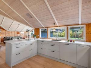 a large kitchen with white cabinets and windows at Holiday Home Bole - 10km from the sea by Interhome in Øster Vrøgum +18 photos