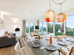 a living room with a dining room table with chairs at Apartment Penthouse Seeblick by Interhome in Lembruch