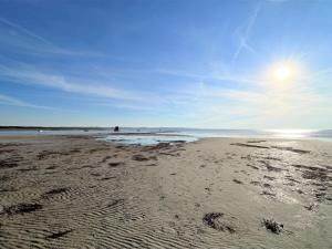 a beach with footprints in the sand and the ocean at Holiday Home Antonina - 775m from the sea by Interhome in Gudmindrup