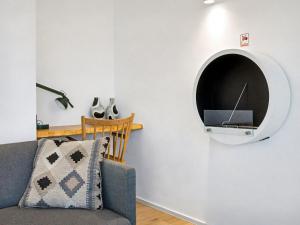 a living room with a couch and a tv on the wall at Apartment Penthouse Seeblick by Interhome in Lembruch +20 photos