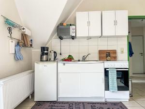 a kitchen with white cabinets and a sink at Apartment Wariner Straße by Interhome in Tempzin