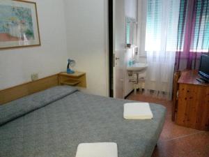 małą sypialnię z łóżkiem i umywalką w obiekcie Hotel Bel Sit w Rapallo
