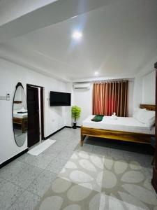 a bedroom with a bed and a television in it at Studio Room in Zanzibar City