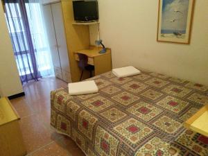 sypialnia z łóżkiem, biurkiem i telewizorem w obiekcie Hotel Bel Sit w Rapallo