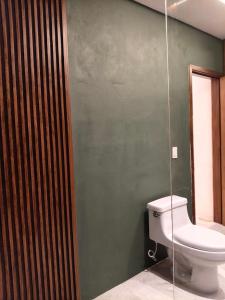 baño con aseo y pared verde en Casa Rocka Boutique Isla Mujeres, en Isla Mujeres