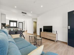 a living room with a blue couch and a tv at Holiday Home Green Garden II-2 by Interhome in Pilar de la Horadada