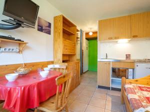 a kitchen with a table with a red table cloth at Apartment Sarvan 208 by Interhome in Les Menuires