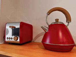 a red tea kettle next to a toaster on a counter at Ruzafa & Oceanografic Suites by Illetes Flats in Valencia