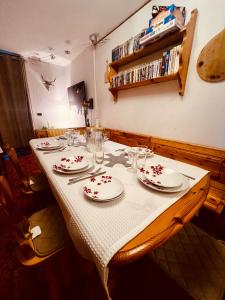 a table with plates and glasses on top of it at La Baita Limone Riserva Bianca Ski-in Ski-out Seggiovia Morel 2 in Limone Piemonte