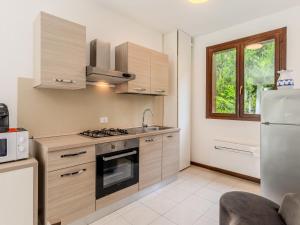 a kitchen with a stove and a sink and a refrigerator at Apartment Borgo Castello-9 by Interhome in Argegno +12 photos