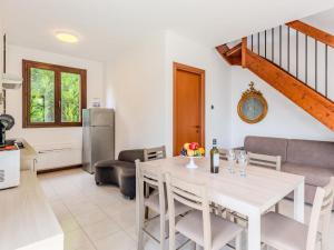 a kitchen and living room with a white table and chairs at Apartment Borgo Castello-9 by Interhome in Argegno