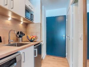 a blue door in a kitchen with a sink at Studio Les Olympiades-16 by Interhome in Val Thorens