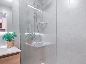 a white bathroom with a sink and a shower at Studio Les Olympiades-16 by Interhome in Val Thorens