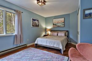 a bedroom with blue walls and a bed and a chair at Renovated 4BR House - Hot Tub, Game Room & Fire Pit - 11 Mins to Killington Lifts & Dining in Telemark Village