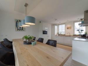 eine Küche und ein Esszimmer mit einem Holztisch und Stühlen in der Unterkunft Holiday Home Ganuenta by Interhome in Colijnsplaat