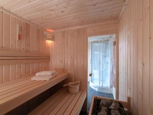 eine Holzsauna mit einer Bank und einem Fenster in der Unterkunft Holiday Home Ganuenta by Interhome in Colijnsplaat