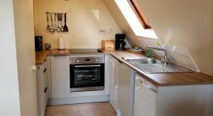 a small kitchen with a sink and a stove at Highland Glen Lodges in Rogart