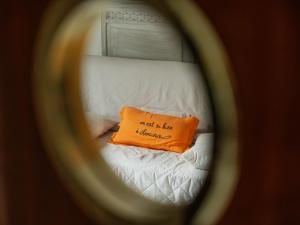 ein orangefarbenes Kissen auf einem Bett in der Unterkunft Holiday Home Monoi by Interhome in Lancieux