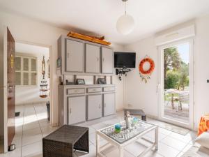 ein Wohnzimmer mit weißen Schränken und einem Tisch in der Unterkunft Holiday Home Monoi by Interhome in Lancieux