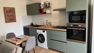 eine Küche mit einer Waschmaschine und einem Tisch mit Stühlen in der Unterkunft Longanea 1 in Saint-Pierre + 3 Fotos