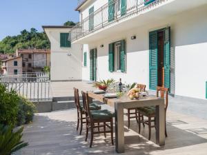 a wooden table and chairs on a patio at Holiday Home Casa Gli Aranci by Interhome in Montignoso