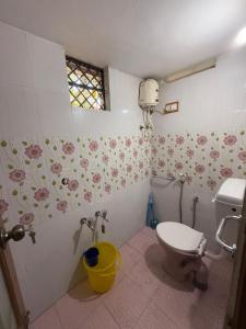 Mūvattupulaheritage mansion的浴室配有卫生间,墙上挂有鲜花