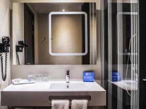 a bathroom with a sink and a mirror at Novotel Madrid Center in Madrid +104 photos