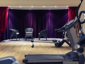 a gym with chairs and a stage with purple curtains at Mercure Maurepas Saint Quentin in Maurepas