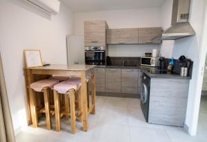 a kitchen with a wooden table and stools at N1 Maison T2 climatisé in Ajaccio