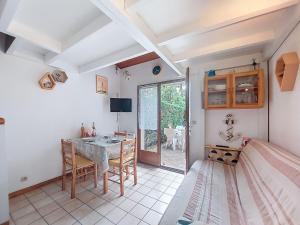 a room with a table and chairs and a bedroom at Holiday Home Les Villas de La Palmyre by Interhome in Les Mathes