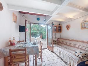 a dining room with a table and a bed at Holiday Home Les Villas de La Palmyre by Interhome in Les Mathes +28 photos