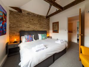 a bedroom with a large bed with white sheets at Holiday Home Shanty Cottage by Interhome in Mevagissey