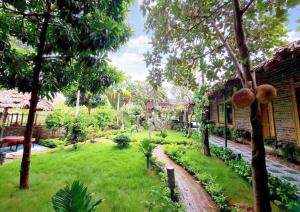 un giardino con erba e alberi e un edificio di Tamcoc Home Garden a Vũ Lâm
