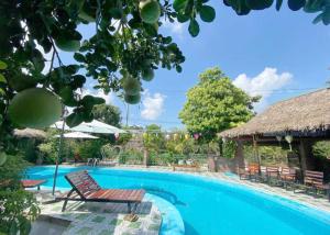 una piscina con sedia e ombrellone di Tamcoc Home Garden a Vũ Lâm