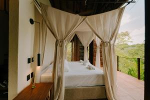 a bedroom with a bed with a canopy at Sandagua hotel in Puerto Triunfo +17 photos