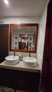 Un baño con dos lavabos y un espejo grande. en Aurora Hostel Inn, en Boracay