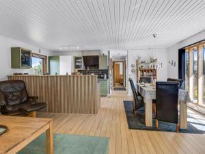 a kitchen and living room with a table and chairs at Holiday Home Naema - 500m from the sea by Interhome in Østerby Havn