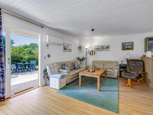 a living room with a couch and a table at Holiday Home Naema - 500m from the sea by Interhome in Østerby Havn