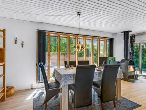 a dining room with a table and chairs and a fireplace at Holiday Home Naema - 500m from the sea by Interhome in Østerby Havn +15 photos