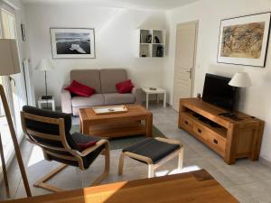 a living room with a couch and a tv at La Parenthèse du Remoray in Labergement-Sainte-Marie