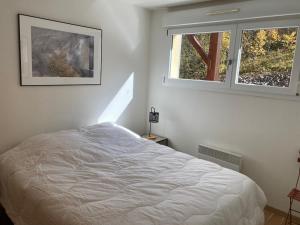 a bedroom with a white bed and two windows at La Parenthèse du Remoray in Labergement-Sainte-Marie