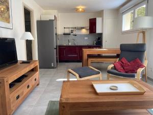 a living room with a television and a kitchen at La Parenthèse du Remoray in Labergement-Sainte-Marie