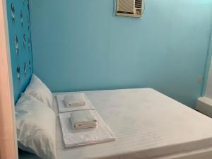Una cama en una habitación con dos toallas encima. en Aurora Hostel Inn, en Boracay 9 fotos más