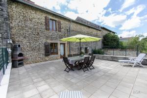 a patio with a table and a yellow umbrella at Steinhaus In Ländlicher Umgebung Mit Pool in Brotte-lès-Ray