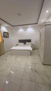 a bedroom with a bed and a marble floor at samba alula in Al ‘Azīzīyah
