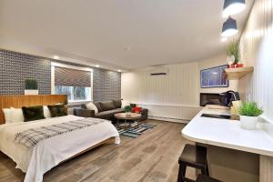 a bedroom with a bed and a living room at Modern Studio for 4 Near Killington with Fireplace, Summer Pool & EV Charger in The Woods +12 photos