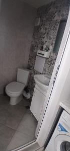 a bathroom with a toilet and a sink at Студио за двама в центъра на град Бургас in Burgas City +3 photos