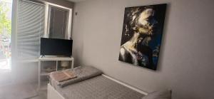 a living room with a picture of a man on the wall at Студио за двама в центъра на град Бургас in Burgas City