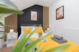 a bedroom with a bed with a yellow blanket at Open Mind Property - Cozy 4BR Flat & 12 Guests in Littlehampton